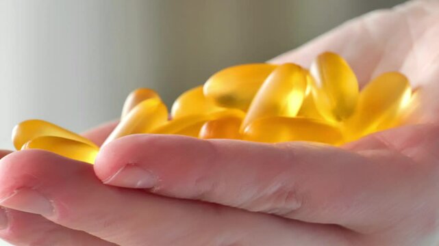 Omega acid capsules.Soft gelatin capsules of fish oil in female hands. Fish oil capsules in female hands.4k footage