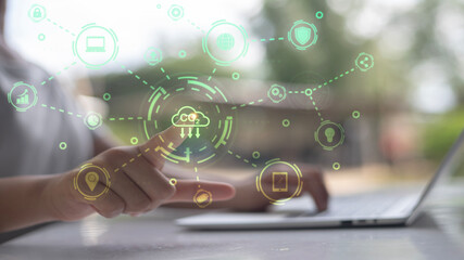 A person is pointing at a laptop screen with a green cloud symbol