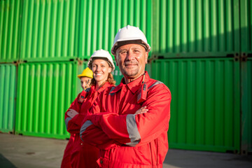 Portrait dockworkers or engineers standing in front of large shipping containers suggests an industrial or shipping environment, likely related to logistics or industry construction business concept.