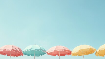 Pastel-colored beach umbrellas lined up against a light blue sky.