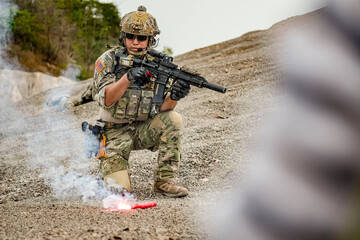 A group of military men in combat gear patrol in the middle of a desert and tropical jungle....