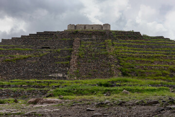 Fototapeta premium pyramid ruins in archaeological zone located in Queretaro, Mexico. Which is surrounded by nature and vegetation, with a cloudy sky which looks beautiful