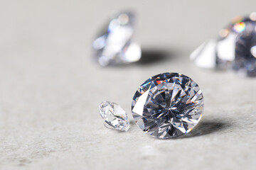 Many beautiful shiny diamonds on light background, closeup