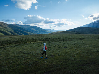 Fototapeta premium Aerial view of woman trail runner in high altitude mountains