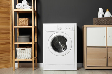 Washing machine, detergents in basket, wooden rack and storage cabinet indoors