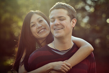 Naklejka premium Love, smile and couple on date in park with embrace, support and trust in interracial relationship together. Nature, man and woman relax in garden for outdoor bonding, happy romance and partnership.