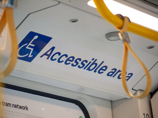The text 'Accessible Area' and the international wheelchair accessibility symbol on a tram in...