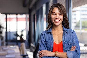 Smiling woman in casual outfit standing confidently in modern office space, copy space