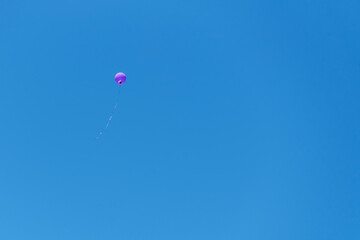 Purple balloon dispersed in total blue.