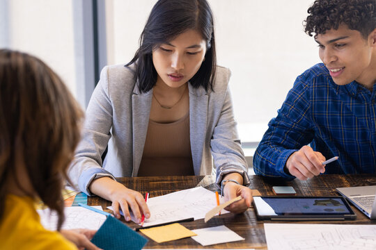 At office, Reviewing blueprints and material samples, diverse team collaborating on project