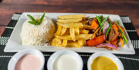 beef lomo saltado, french fries and rice, served with homemade creams, peruvian food
