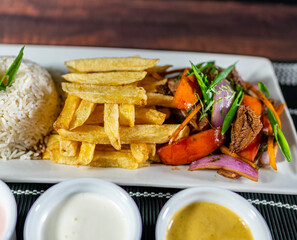 beef lomo saltado, french fries and rice, served with homemade creams, peruvian food
