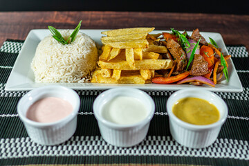 beef lomo saltado, french fries and rice, served with homemade creams, peruvian food
