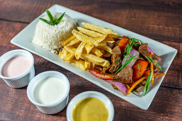 beef lomo saltado, french fries and rice, served with homemade creams, peruvian food