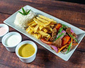 beef lomo saltado, french fries and rice, served with homemade creams, peruvian food