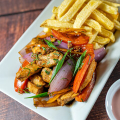 sautéed chicken with french fries and rice, served with homemade creams, peruvian food