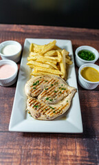 grilled chicken with french fries and fresh salad, accompanied by homemade creams.