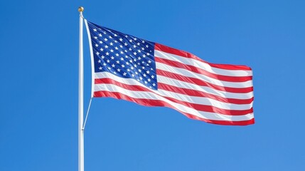 Fototapeta premium American Flag Waving in the Wind Against a Blue Sky