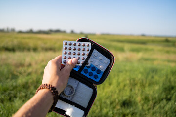 A hand gently holding medication amidst the serenity of nature, representing a holistic health and wellness concept that blends natural healing with modern medicine