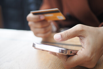  women hand holding credit card and using smart phone shopping online 