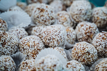 A mouthwatering and tempting stack of delicious coconut balls is elegantly displayed on the table, just waiting to be savored and enjoyed by those who truly appreciate delightful desserts