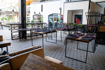 The restaurant is currently empty, and within it can be seen an array of tables and chairs stacked awkwardly, forming a surreal and intriguing sight that certainly invites curiosity