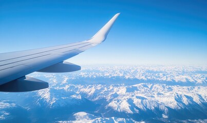 Fototapeta premium Airplane Wing Over Snowy Mountain Range