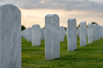 American army national cemetery with rows of white headstones on green grass lawn. Memorial Day concept