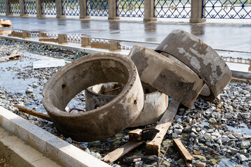 Abandoned and neglected concrete rings along with debris found throughout an urban setting or environment