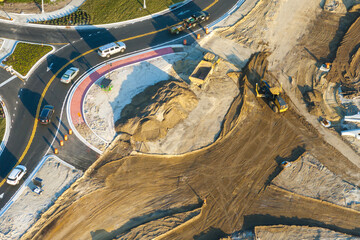 Driving traffic cars at roundabout intersection under construction. Building traffic circle on American road with moving cars