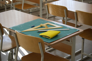 Classroom desk with math tools, ruler, and eraser on a cutting mat
