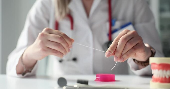 Dentist demonstrates proper flossing techniques in a clinic to improve oral hygiene