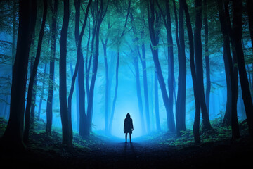 Fototapeta premium Into the Blue Abyss: A lone figure shrouded in mystery stands amidst a fog-choked, blue-lit forest, evoking an eerie and suspenseful atmosphere. 