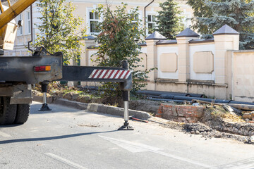 Naklejka premium A crane is parked on the side of the road in front of a building