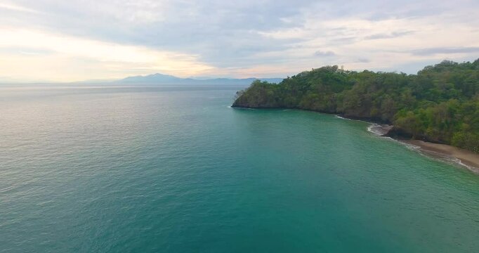 Flying parallel to a white sand beach on Tortuga Island in Costa Rica during a beautiful summer sunrise