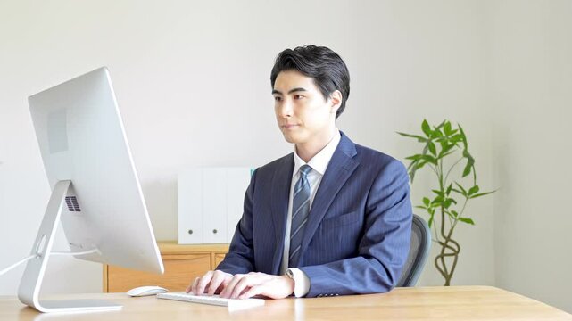 パソコン作業をするスーツを着た男性