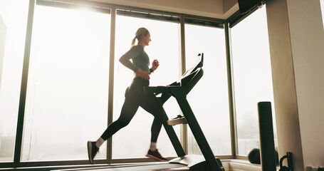 Woman, fitness and running on treadmill at gym for cardio exercise, workout and training performance. Active, female person and machine for morning routine, endurance or speed challenge of resilience