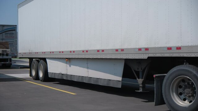 Trailers for semi-trucks in the parking lot. Move camera