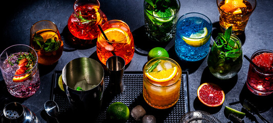 Alcoholic cocktails, top view. Set of colorful drinks for party. Black background, bar tools, hard...