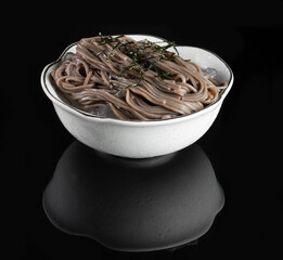 A bowl of cold soba noodles with seaweed garnish in white dish. Perfect for healthy and refreshing...