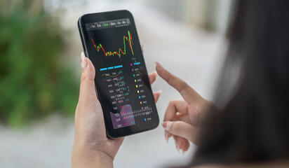 Hand hold smartphone with stock market chart financial trading, online investment, stock exchange...