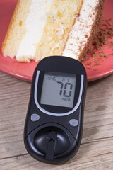Glucometer with good result of sugar level and cake with layers and chocolate. Nutrition during...