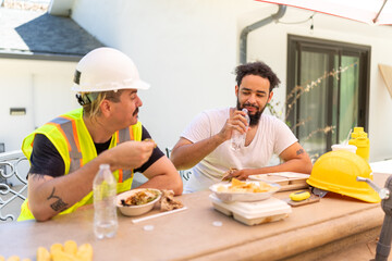 Two men enjoying a break during house remodeling, showcasing teamwork and camaraderie at the construction site