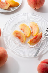 Cut peaches on a plate on white background.