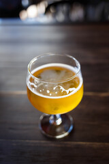 Enjoying a refreshing craft beer on a wooden bar table in a cozy setting