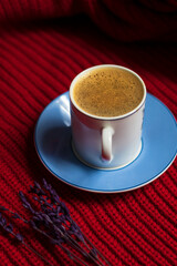 Turkish coffee with plenty of foam and coffee beans on red background