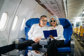 Senior Asian couple capturing memories on a plane, blending travel with technology. Smiling, stylish,