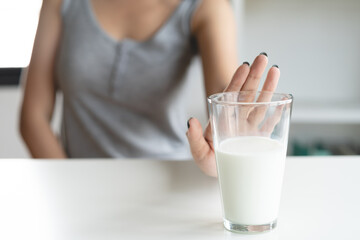 lactose intolerance concept. Woman holding a glass of milk and having a stomachache.