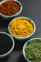 Traditional oriental spices in ceramic bowls. black cumin seed, ground red pepper, dried mint, himalayan ​​salt.
