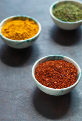 Traditional oriental spices in ceramic bowls. black cumin seed, ground red pepper, dried mint, himalayan ​​salt.